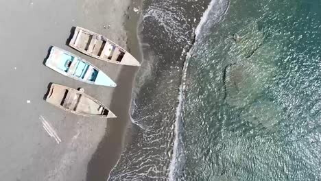 Toma-Aérea-De-La-Orilla-De-La-Playa-De-Ocoa,-Mar-Tranquilo-Con-Botes-Estacionados,-Hermoso-Día-Soleado