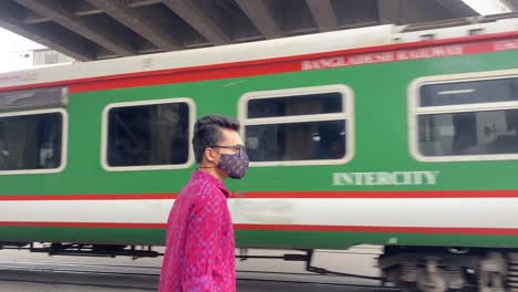 young traveler man watching empty train passing during pandemic at bangladesh