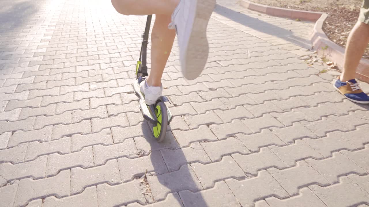 남자 발이 도시에서 스쿠터를 타고 있습니다.