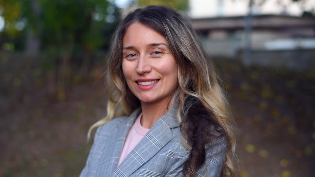 Primer plano de una mujer rubia sonriendo a la cámara en el parque