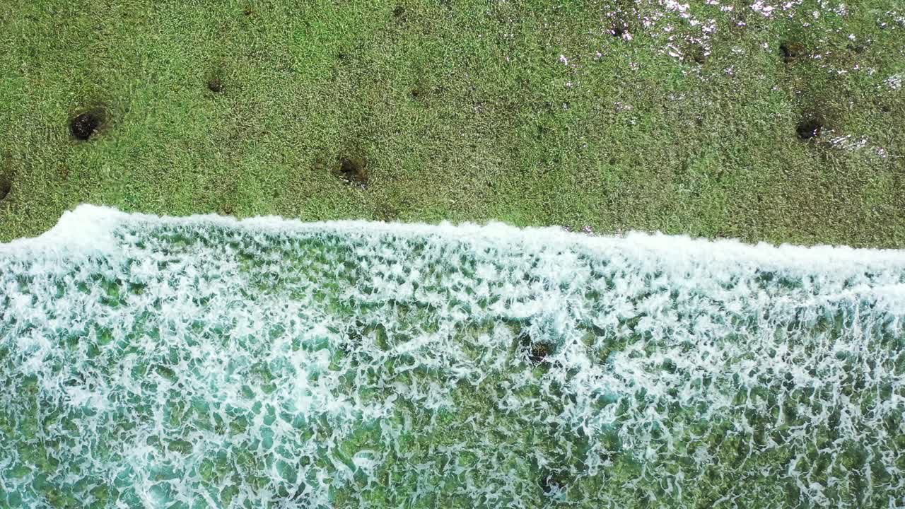 Beautiful white waves spreading over shallow calm lagoon, foaming on rocks and coral reefs, sea texture in Cook islands