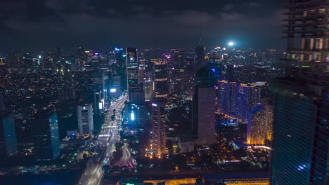 Hyper-Lapse-Motion-Time-Lapse-at-Night-above-of-modern-city-center-with-skyscrapers-and-busy-car-traffic-in-futuristic-modern-Jakarta,-Indonesia,-Aerial-Drone-hyperlapse-Establishing-Shot