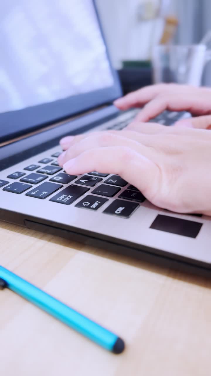 University student typing on laptop keyboard during online class