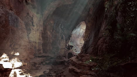 sunlight shines through a dark cave in the mountains