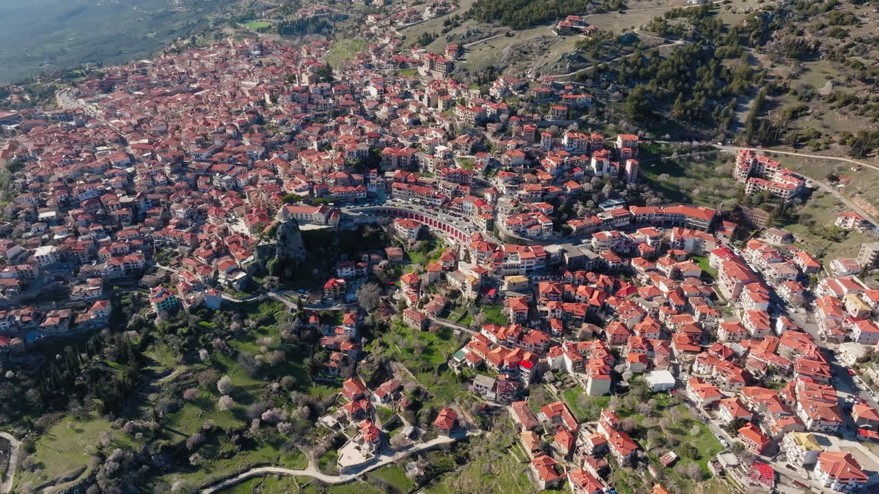 High altitude overview of mountainous Arachova, Greece with clear skies and valley below, aerial