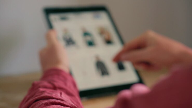 Person Browsing Online Clothing Store on a Tablet