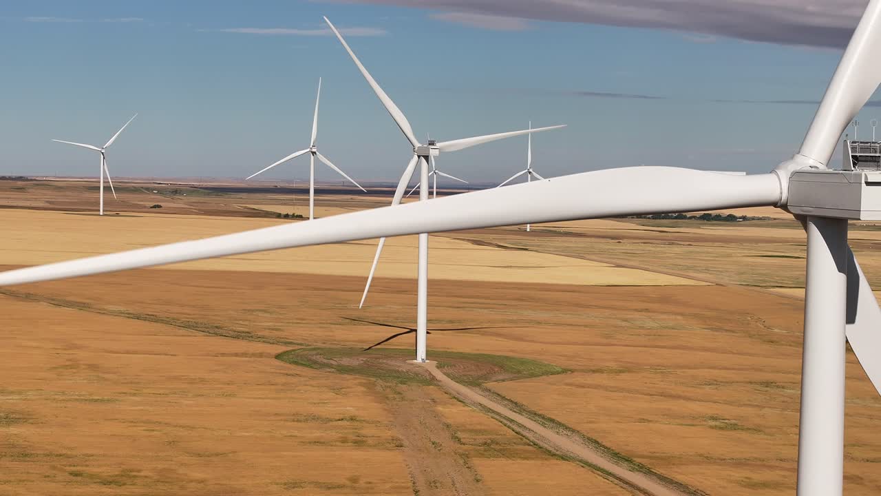 A drone flies across a prairie farmland wind farm in southern Alberta, Canada