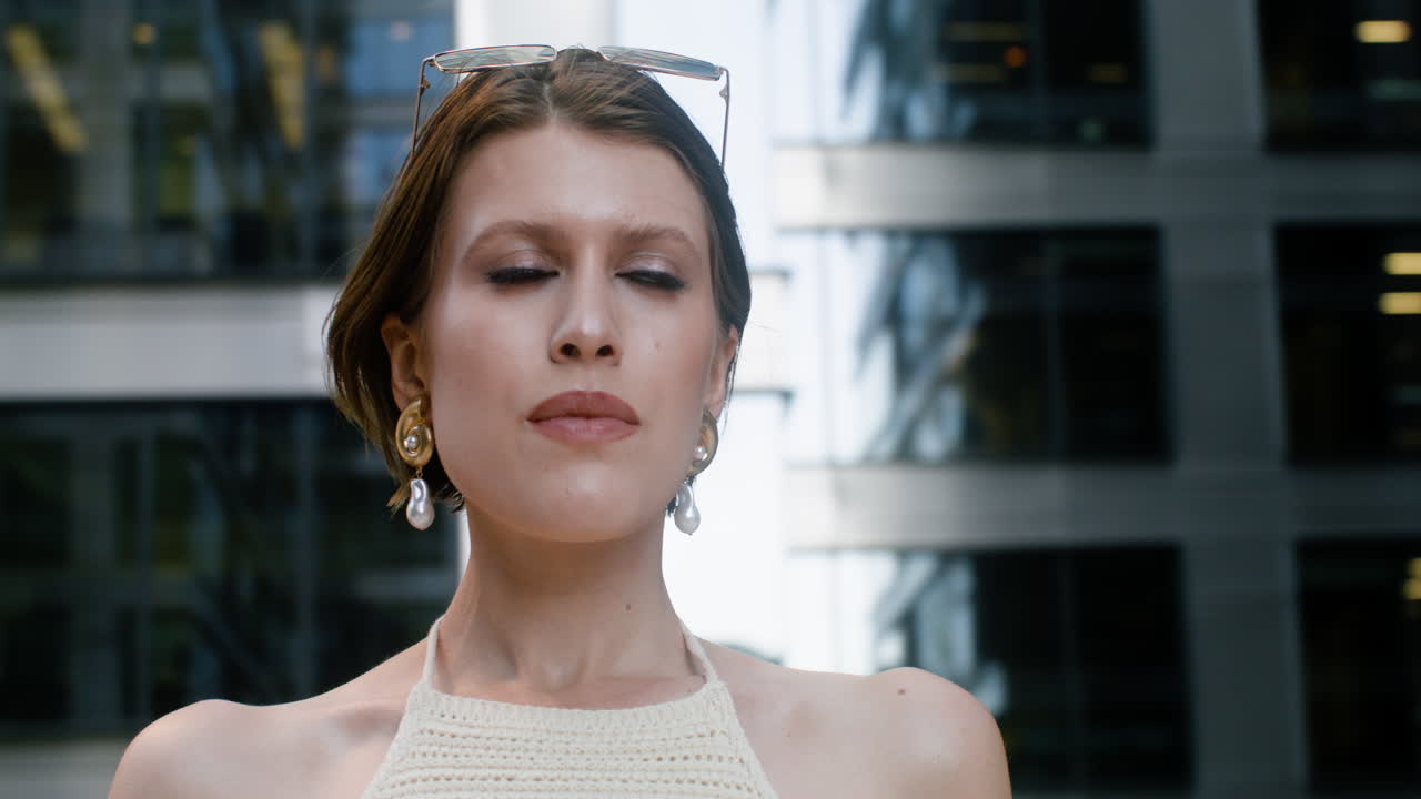 близкий взгляд на элегантную женщину с солнцезащитными очками на голове