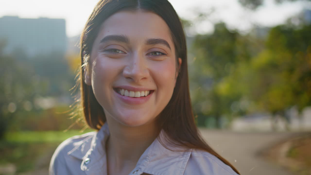 mujer feliz sonriendo retrato en primer plano a la luz del sol dorado. chica relajada en el parque