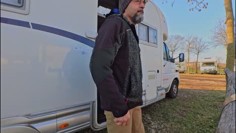 un hombre con un sombrero de punto sale de su caravana