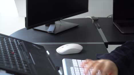 Working-from-home-during-the-global-pandemic,-wearing-a-dressing-gown-using-a-laptop-and-mouse