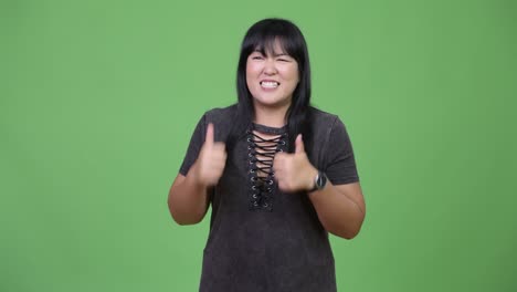 happy overweight asian woman giving thumbs up