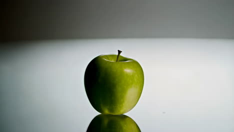 green apple on a reflective surface