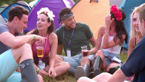 Friends-sitting-at-a-music-festival-campsite,-close-up