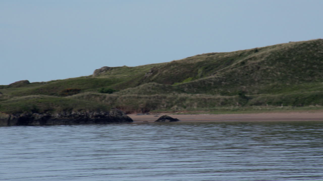panning shot of Ynys Llanddwyn island on Llanddwyn beach at the Newborough National Nature Reserve