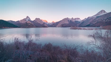 riaño snowy peak during sunrise reflection in water reservoir