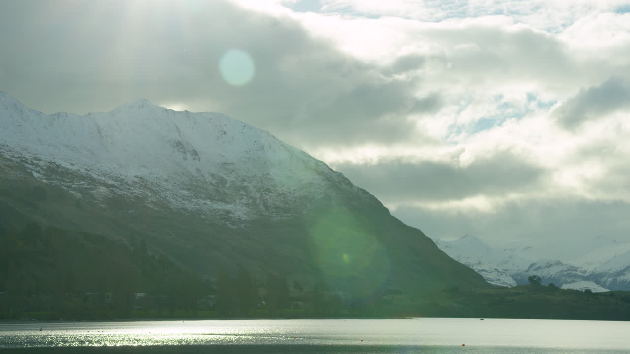 Snowy mountain storm clouds by lake Time Lapse.