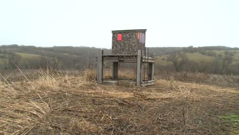 a hunting blind looking over a corn field in iowa, wide shot