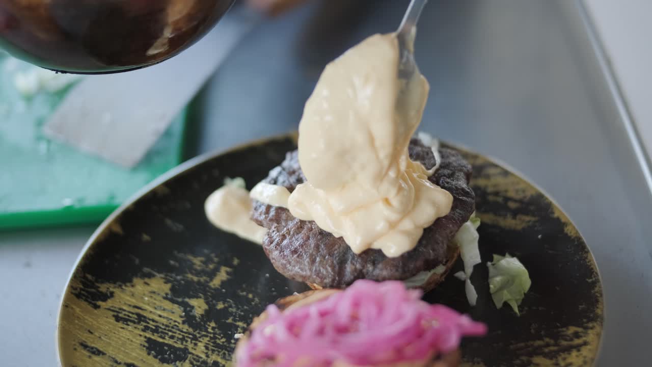 셰프가 야외 그릴에서 햄버거를 고 있습니다.