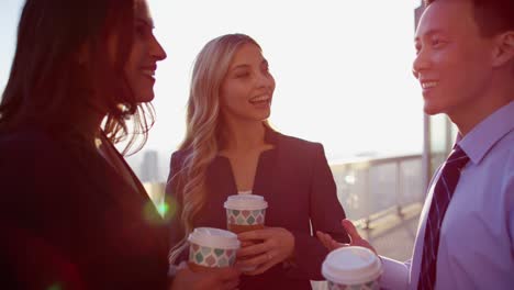 multi ethnic business managers drinking coffee on rooftop