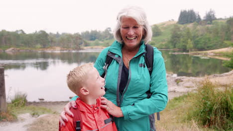 Großmutter-Und-Enkel-Stehen-Zusammen-In-Der-Nähe-Eines-Sees-Auf-Dem-Land-Und-Lachen,-Nahaufnahme,-Seenplatte,-Großbritannien