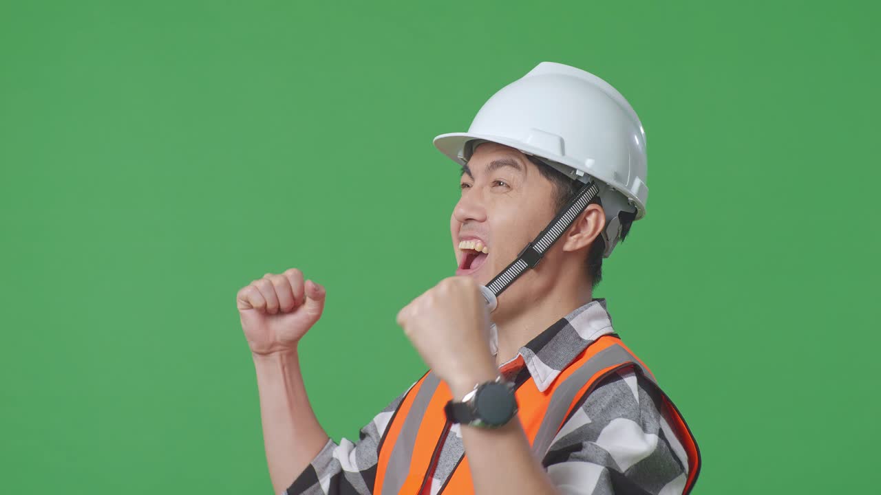 Close Up Of Side View Of Asian Male Engineer With Safety Helmet Screaming Goal Celebrating Working In The Green Screen Background Studio