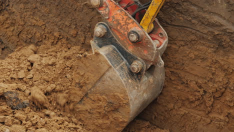 trabajos de excavación en un sitio de construcción el cucharón de la excavadora recoge el suelo y lo levanta