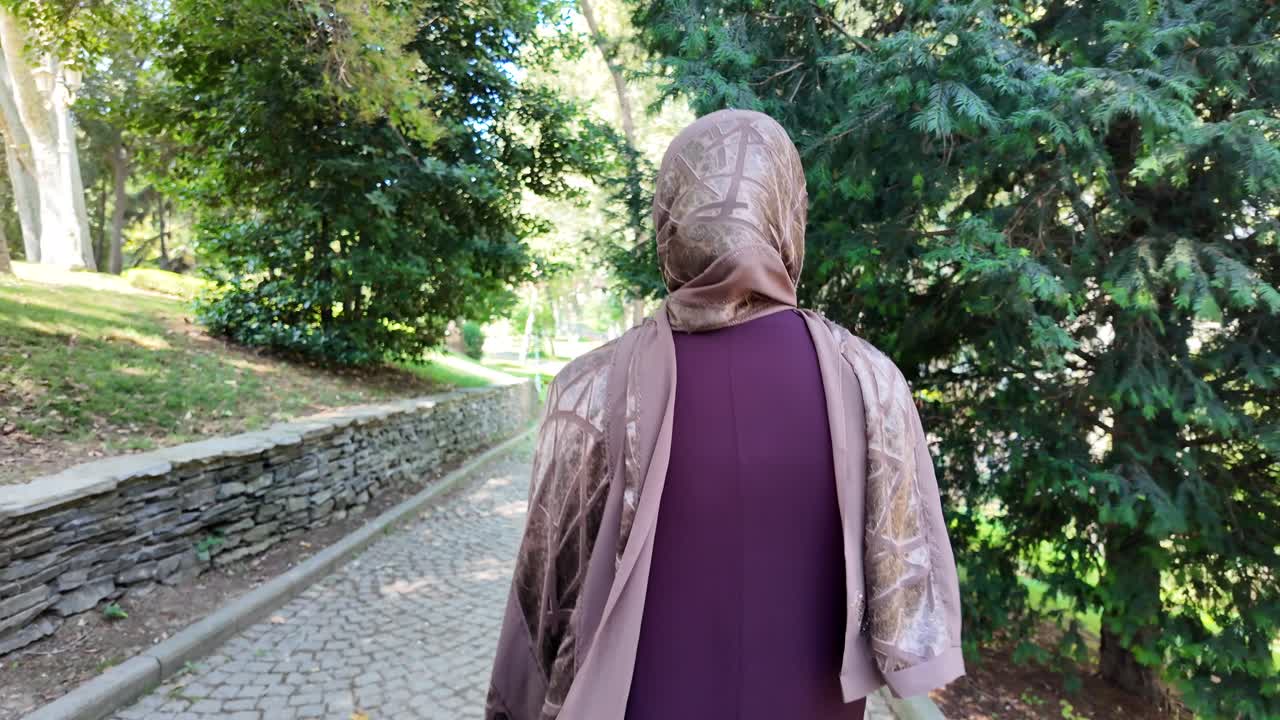 Donna con hijab che cammina nel parco