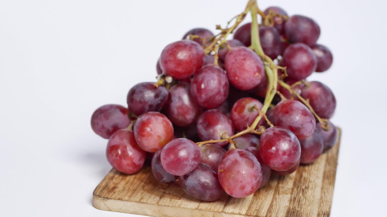 uvas rojas en una tabla de cortar de madera