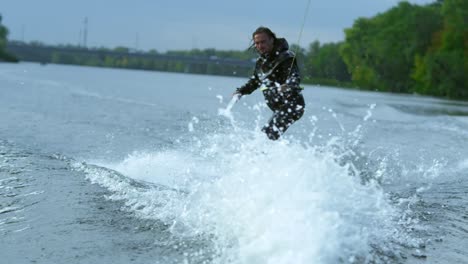 Young-man-on-wakeboard-dissecting-river-waves-in-slow-motion.-Extreme-holidays