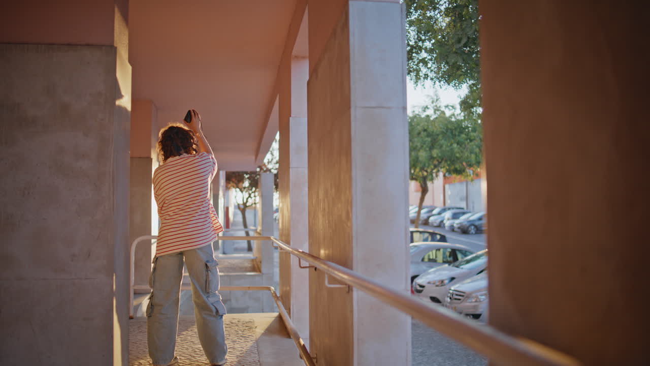 auriculares de vista trasera mujer moviéndose con tacto canción favorita en la calle de la noche.