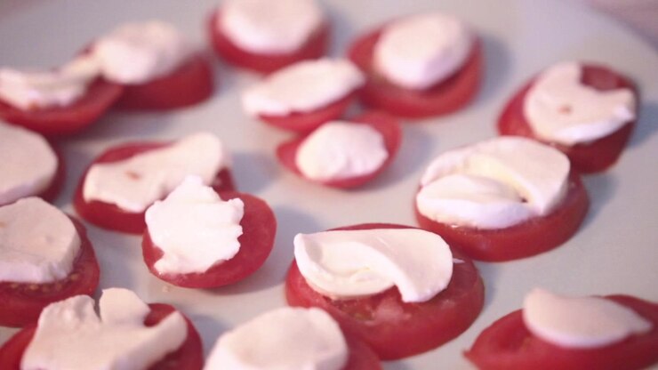 A close up of mozzarella on tomato slices