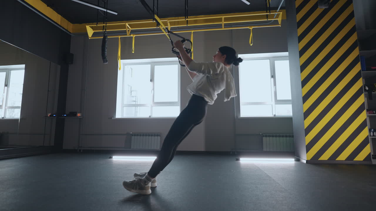 mujer de fitness ejercicio de entrenamiento con equipo trx en el gimnasio de fitness estilo de vida saludable construcción de cuerpo fuerte y en forma. mujer atractiva haciendo entrenamiento de core abs crossfit con correas de fitness en el gimnasio