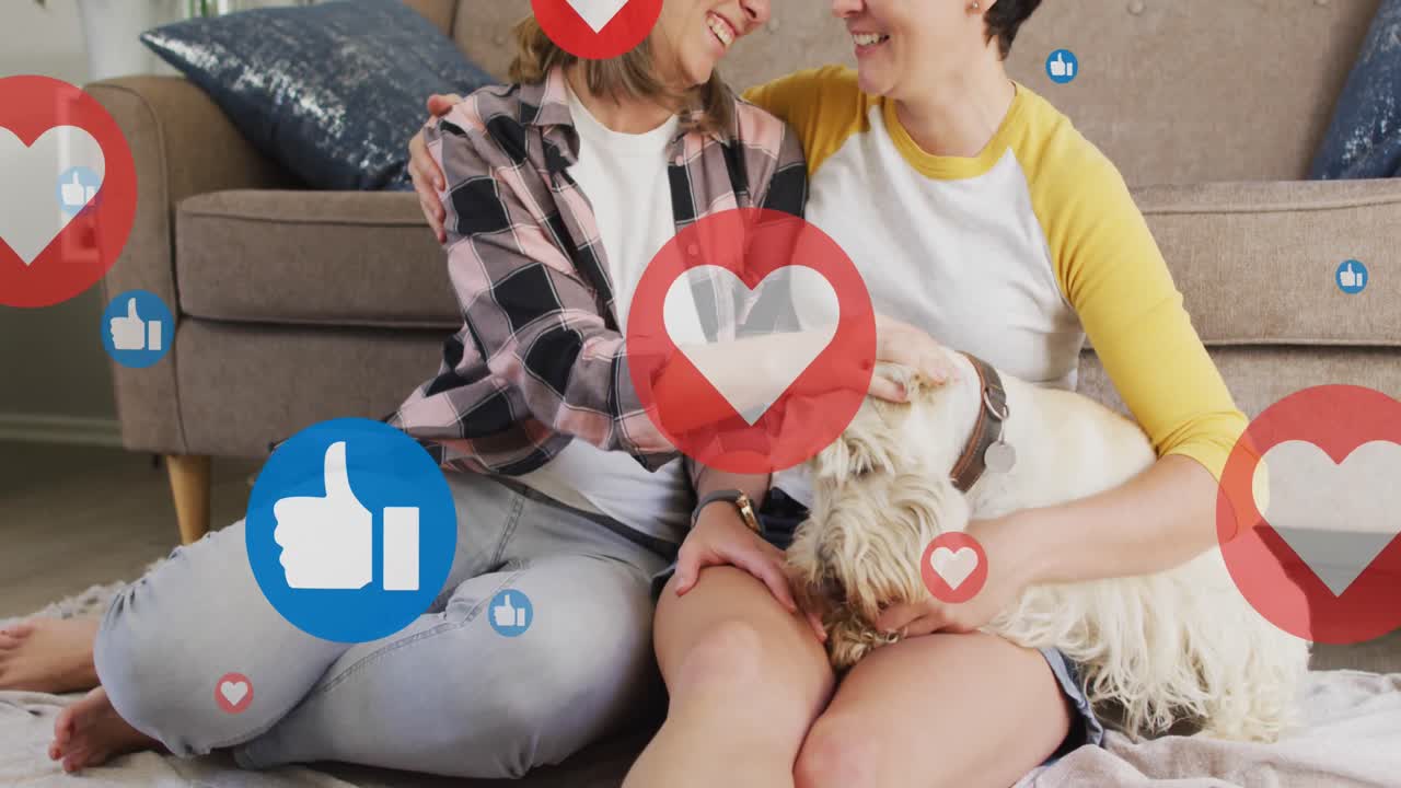 animación de corazones y como iconos sobre pareja de mujeres caucásicas sentadas en el sofá con su perro mascota.