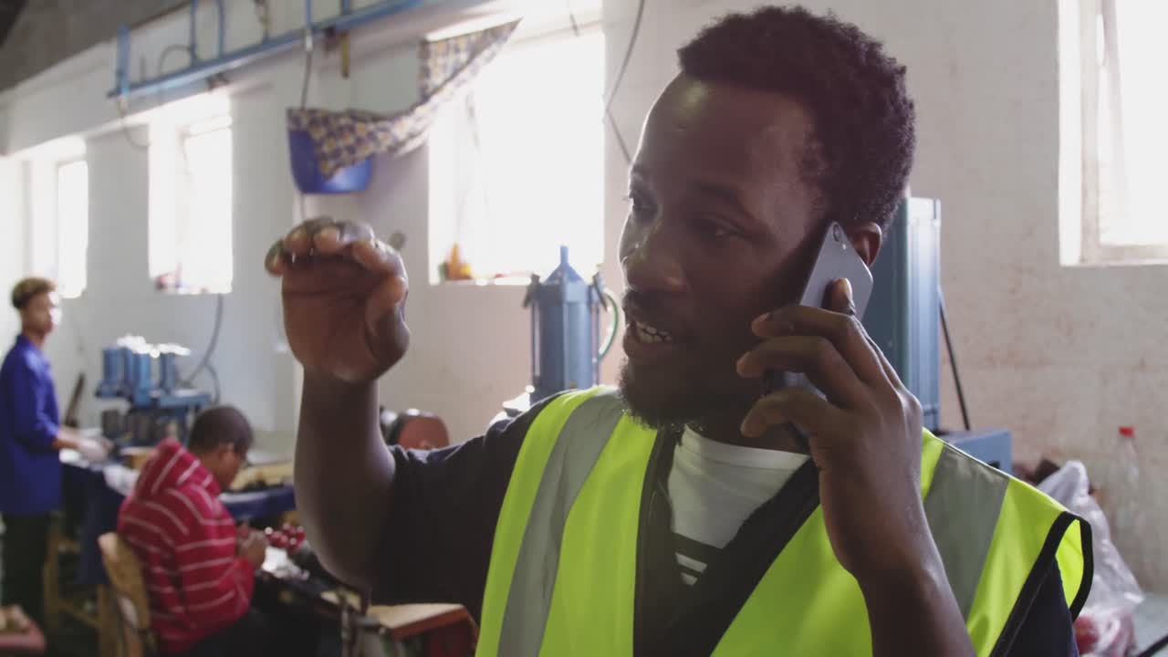 Mixed race man phoning in factory