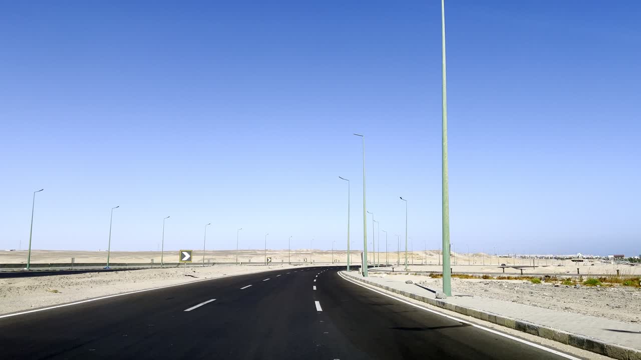 이집트 중동의 후르가다에서 사막으로 포장된 도로를 운전하고 있습니다.