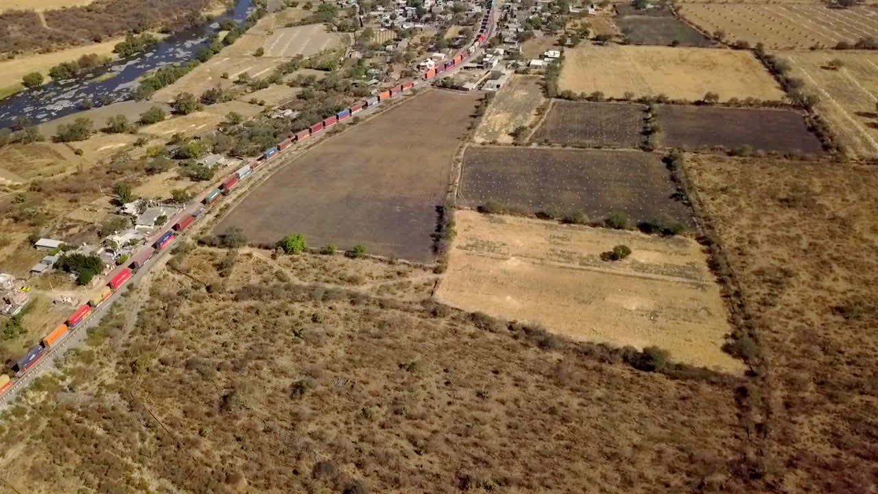 toma de drones de varios vagones de tren en una vía férrea que pasa por una ciudad durante el día