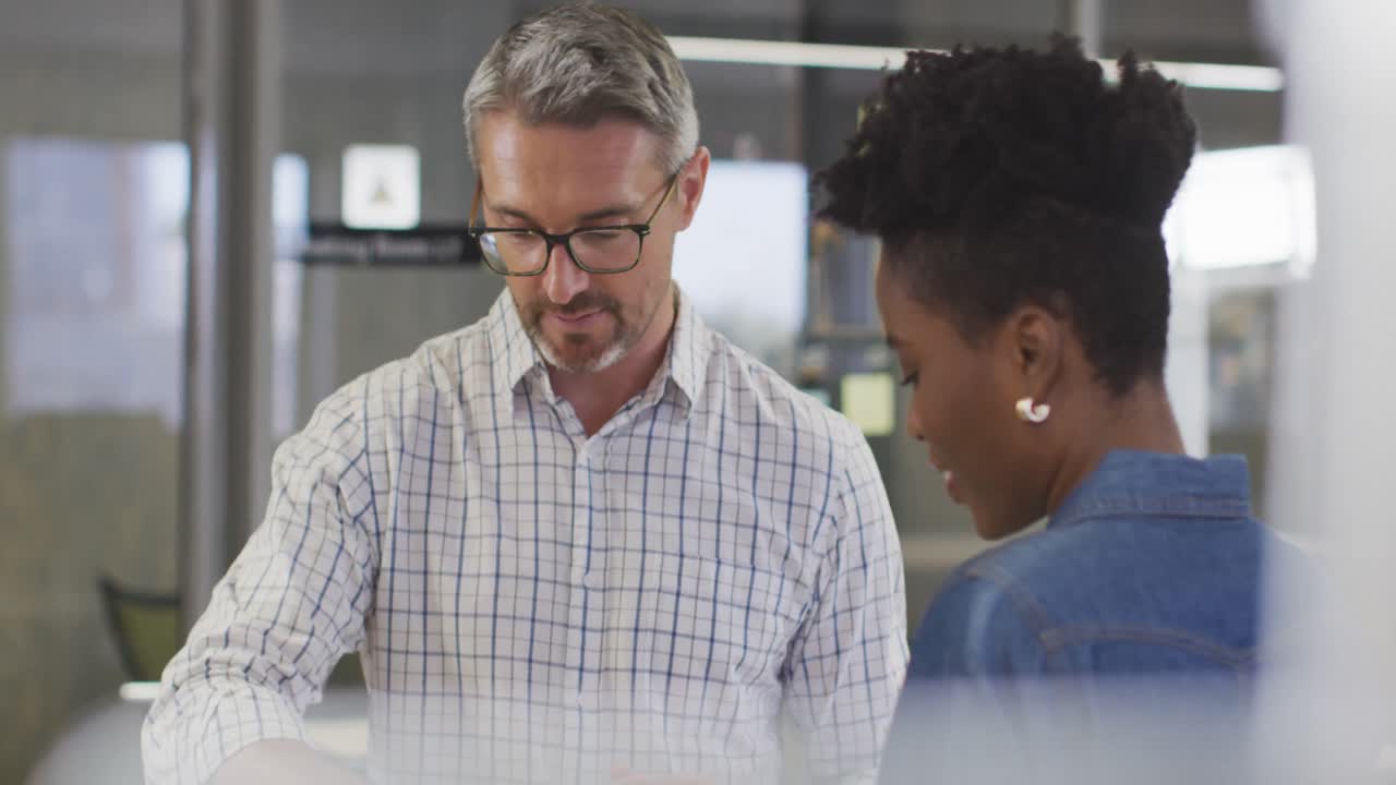 Video of diverse businessman and businesswoman talking about project