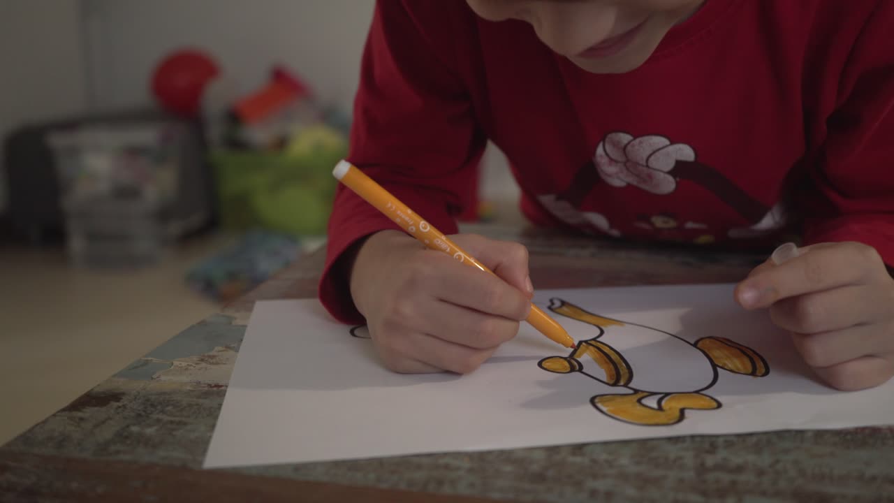 실내에서 노란색 마커를 사용하여 마술 램프 그리기를 그리는 백인 소년