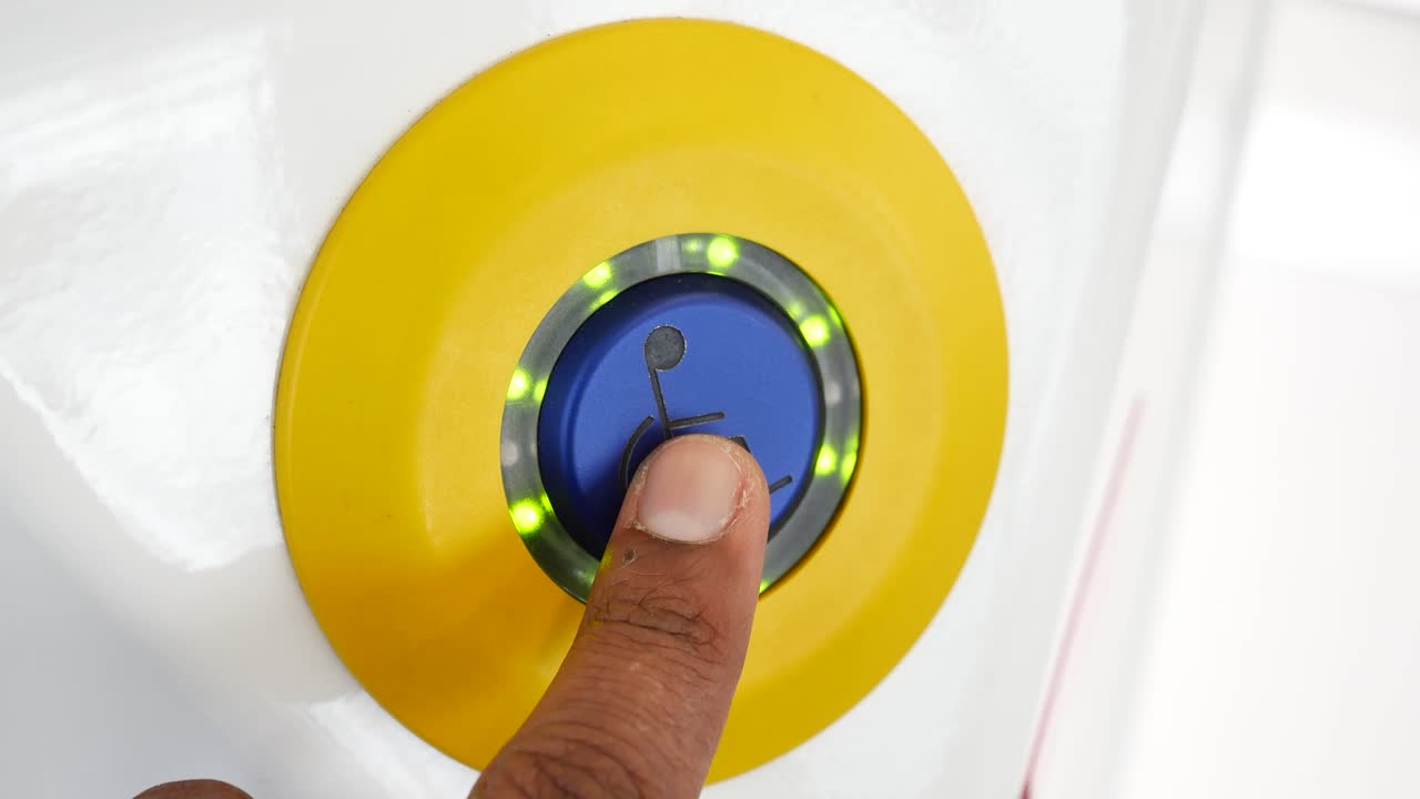 persona que presiona un botón de acceso para silla de ruedas
