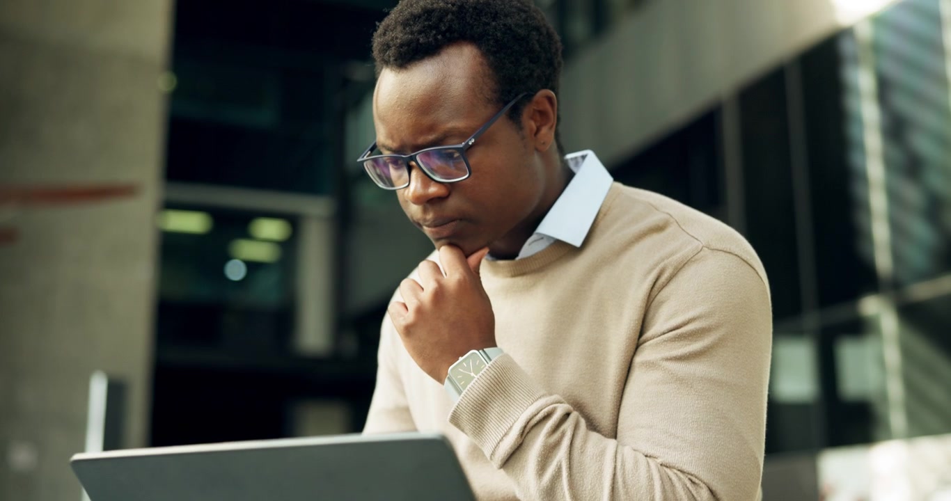Focused Professional Man Working on Laptop Outdoors