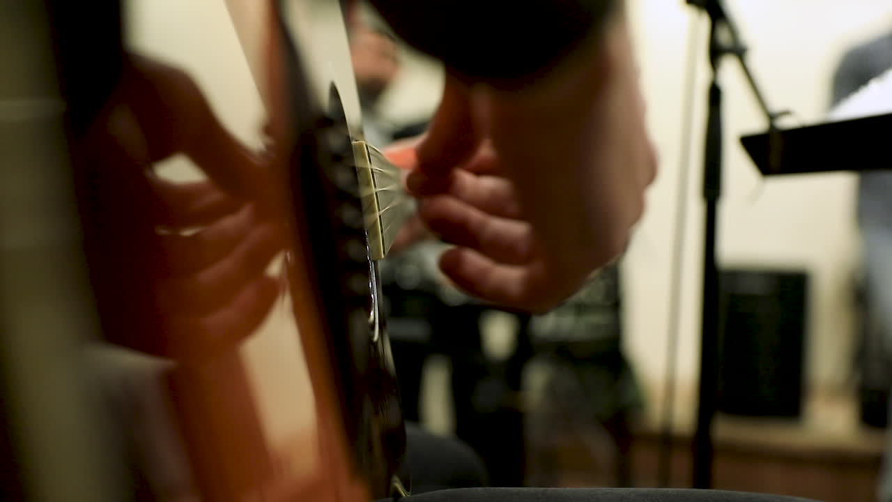 Close-up of a male hand playing the guitar in the studio