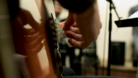 close-up of a male hand playing the guitar in the studio