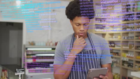 Animation-of-data-processing-over-african-american-male-shop-assistant-using-tablet