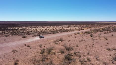 un coche safari 4x4 conduce por una larga carretera en namibia