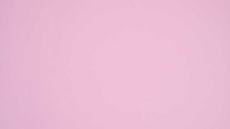 Sweets candies and lollipops appear under paper card note on pastel pink background. Stop motion flat lay