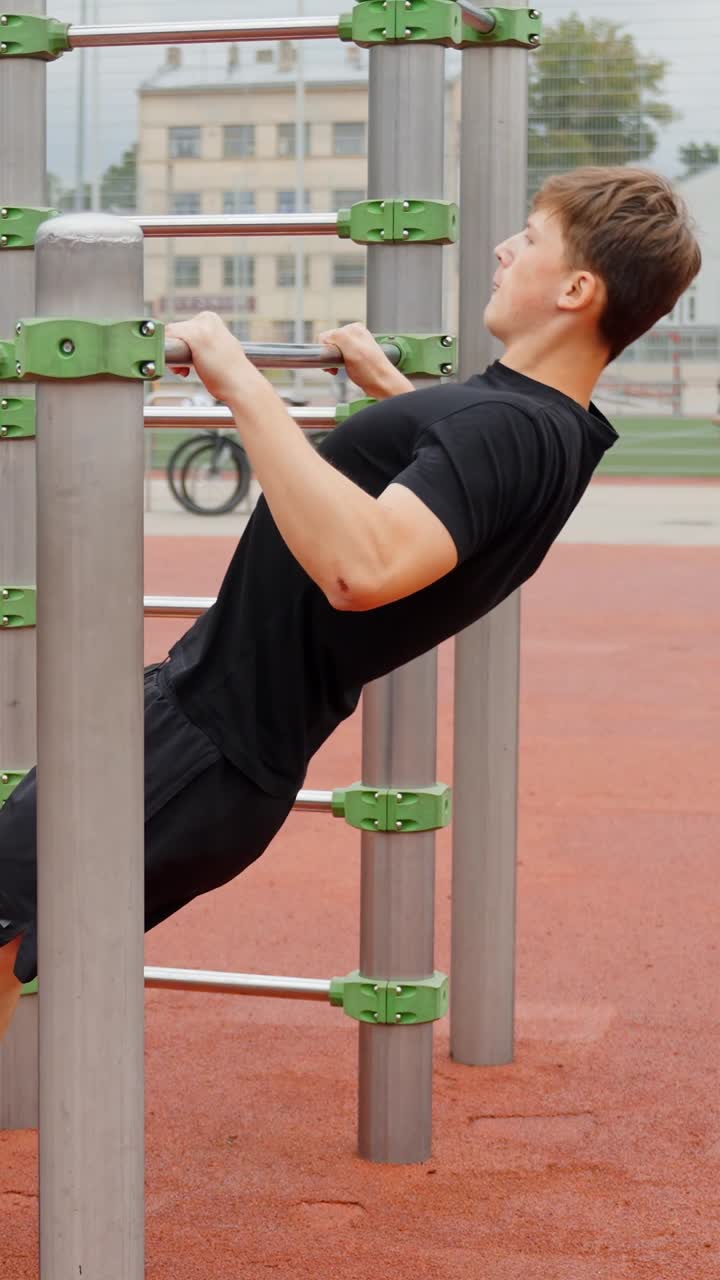 Man Doing A Bodyweight Row Exercise In An Outdoor Gym. - vertical shot
