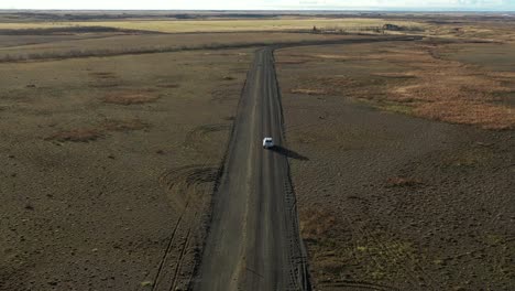 view from above car driving along dark sand road, icelandic landscape