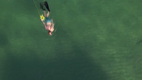 a top down view of a man snorkeling in the green waters of the atlantic ocean in fort lauderdale, florida on a sunny day