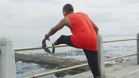 rear view man with prosthetic leg stretching